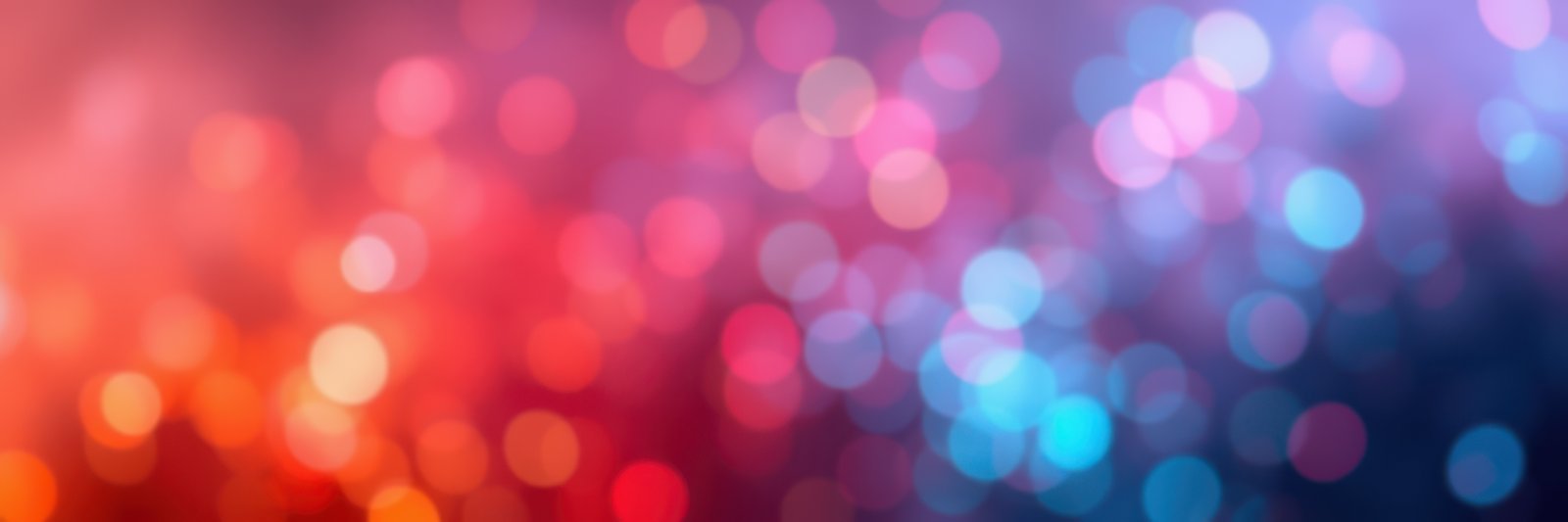 Colorful bokeh background featuring vibrant lights in shades of red, pink, and blue during a festive event at night